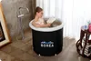 A woman is relaxing in a portable bathtub, reading a book. Produktbild-Vorschau