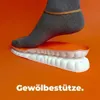 Orange und weiße Schuheinlage mit einem Fuß in einer grauen Socke, der darauf drückt, mit Fußgewölbeunterstützung Produktbild-Vorschau