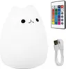 A white cat-shaped LED night light with a remote control and a USB charging cable. Produktbild-Vorschau