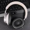 A pair of headphones rests on a keyboard. Voir les images du produit