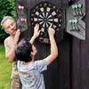 An older man and a younger boy are playing darts outdoors. Náhľad obrázku produktu