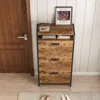 A shoe cabinet with three drawers and an open shelf, placed in a hallway next to a wooden door. Náhľad obrázku produktu