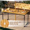An outdoor table with an umbrella hole, set on a patio with some decorative items and plants. Produktbild-Vorschau