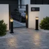 A modern driveway with a black gate, a car visible behind it, and two black bollard lights illuminating the paved walkway. Náhľad obrázku produktu