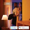 A couple is standing in a doorway, illuminated by warm and cool lighting. A lamp is visible in the foreground. Produktbild-Vorschau