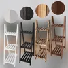 Four different colored wooden plant stands are displayed side-by-side, with circular swatches showing the wood grain and color options above them. Produktbild-Vorschau