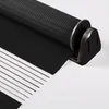 A close-up view of a black and white zebra roller blind, partially unrolled. Náhled obrázku produktu