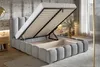 A modern bedroom with a grey upholstered bed frame, the mattress lifted to reveal storage space underneath. A bedside table with a lamp and books is visible to the left, and a large window with sheer curtains is to the right. Produktbild-Vorschau