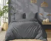 A bedroom scene with a bed made with dark gray bedding, a plant in a pot, and decorative lamps. Produktbild-Vorschau