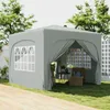 A gray pop-up pavilion with open sides, set up on a grassy lawn next to a wooden deck. Two chairs and a small table are visible inside the pavilion. Podgląd zdjęcia produktu