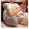 Graues Lesekissen mit Armlehnen, das eine Person stützt, die im Bett sitzt und ein Smartphone hält Náhled obrázku produktu