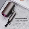 A gray hairdryer with a purple accent is shown on a textured gray surface, with a folded handle. Text overlays describe its features. Náhled obrázku produktu