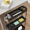 A black rolling storage cart with various office and personal items on a wooden floor next to a desk. Produktbild-Vorschau