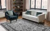 A living room scene with a rug, armchair, and sofa. Produktbild-Vorschau
