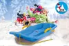 Children sledding down a snowy hill with a blue sled in the foreground. Anteprima dell’immagine prodotto