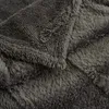 A close-up view of a dark gray, fluffy blanket, showing the texture of the fabric. Produktbild-Vorschau