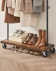 A clothing rack with clothes hanging and shoes on the shelves. Náhled obrázku produktu
