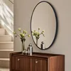A modern dresser with a mirror and decorative items. Produktbild-Vorschau