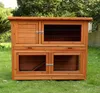 A wooden rabbit hutch with multiple compartments, set up outdoors on a grassy lawn. Produktbild-Vorschau