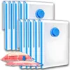 A set of vacuum storage bags with blue accents and a blue valve, shown in a clean, white setting. Some bags are shown compressed with bedding inside, demonstrating their space-saving function. Voir les images du produit