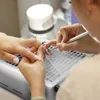 A close-up of a person getting their nails done. Anteprima dell’immagine prodotto