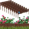 A set of brown wicker garden fences with pointed stakes, displayed in front of pink flowers and green grass. Voir les images du produit