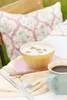 A breakfast setting outdoors with a bowl of cereal and a cup of coffee. Produktbild-Vorschau