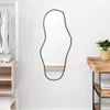 A mirror is shown hanging on a white wall in a room with a closet on the left and a wooden table on the right. Náhled obrázku produktu