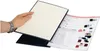 A hand holding a black binder with a white page inside, and a catalog or brochure is partially visible next to it. Produktbild-Vorschau