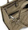 A close-up view of the interior and strap attachment of a quilted tote bag. Voir les images du produit