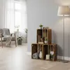 A living room scene with wooden crates used as shelving, a chair, and a floor lamp. Produktbild-Vorschau