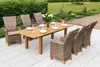 A patio set with a wooden table and wicker chairs in a garden setting. Náhled obrázku produktu