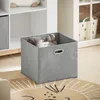 A grey fabric storage cube filled with stuffed toys sits on a rug in a child's room. Podgląd zdjęcia produktu