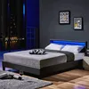 A modern bedroom at night with a bed, nightstand, and city view. Náhled obrázku produktu