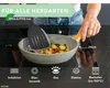 A person is using a frying pan on a stovetop, with food inside. Produktbild-Vorschau