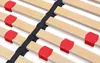 A close-up view of a wooden slatted bed base with red plastic holders and black straps. Produktbild-Vorschau