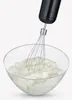 A black hand mixer with a whisk attachment is shown mixing a white substance in a clear glass bowl. Produktbild-Vorschau