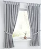 Two curtains are shown hanging on a curtain rod in front of a window. The curtains are tied back with fabric ties. A small vase with flowers sits on the windowsill. Anteprima dell’immagine prodotto
