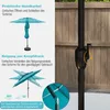 A diagram illustrating the features of a patio umbrella, including its crank mechanism and tilt function, set against a blurred background of a wooden fence and patio. Podgląd zdjęcia produktu