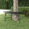 A black metal bench is placed on a grassy lawn next to a tree trunk. Podgląd zdjęcia produktu