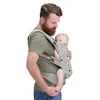 A man is holding a baby in a carrier. Náhled obrázku produktu