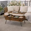 A coffee table with storage is placed on a balcony next to a sofa, with plants and flowers in the background. Produktbild-Vorschau