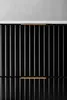 A close-up view of a black cabinet with vertical fluting and gold handles. Anteprima dell’immagine prodotto