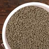 A close-up view of animal feed pellets in a white bucket, set against a wooden background. Produktbild-Vorschau