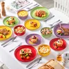 A collection of colorful ceramic plates and bowls filled with various dishes, arranged on a white tablecloth. Náhled obrázku produktu