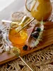 A cocktail drink with garnishes and bar tools on a woven placemat and wooden board. Produktbild-Vorschau