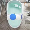 A bathtub with a bath seat and a blue disc inside, placed on a wooden floor. Náhľad obrázku produktu