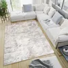A modern living room with a large sectional sofa and a patterned rug. Anteprima dell’immagine prodotto
