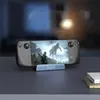 A handheld gaming device is docked and displaying a game on its screen. Produktbild-Vorschau