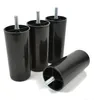 Four black plastic furniture feet with metal threaded bolts are shown on a white background. Voir les images du produit